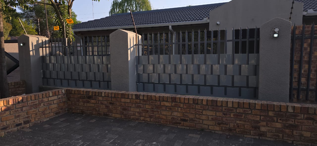 Modern metal slat fence and gate installation